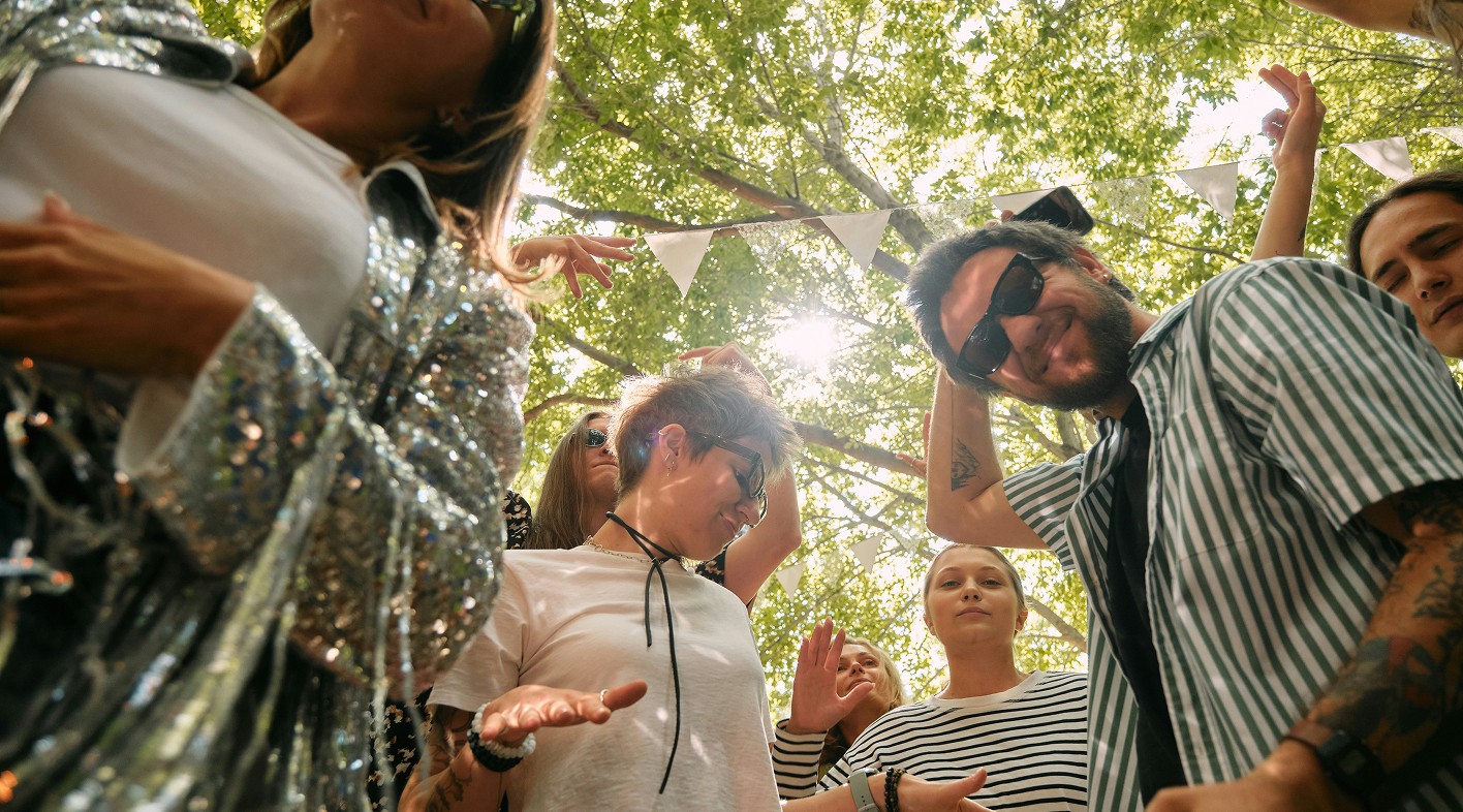 Mensen dansen tussen de bomen op een festival van White Rabbit